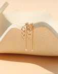 Gold stud earrings with freshwater pearls, chain link details, and a modern minimalist design, featuring the Alex Pearl Stud Earrings displayed in warm natural light.