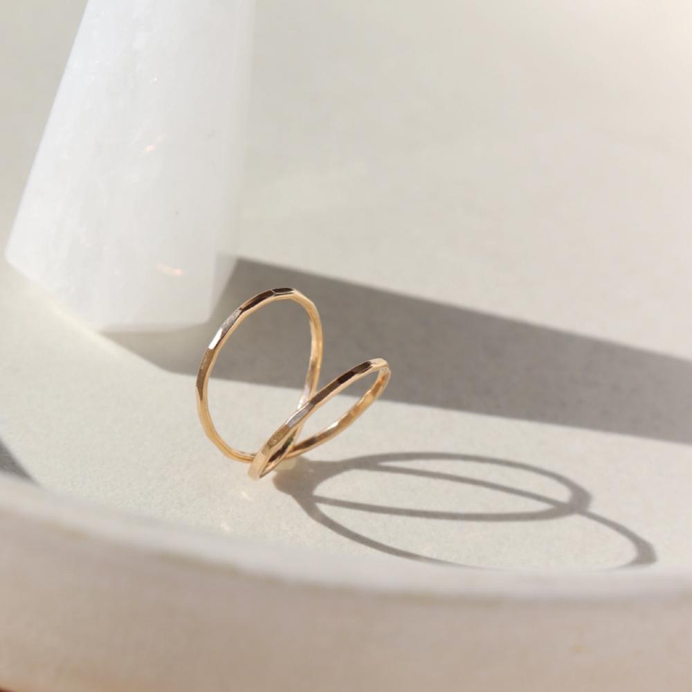14k gold fill infinity Ring laid on a white plate.