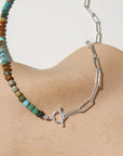 Taos Toggle Necklace featuring half turquoise beads and half silver paperclip chain with a front toggle clasp displayed against a cream back drop