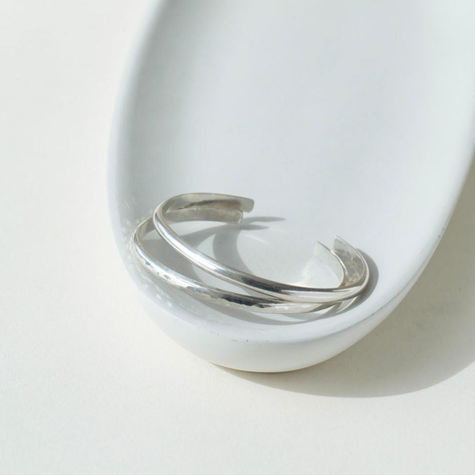 925 stacking cuff placed on a light gray plate, set in the sunlight.