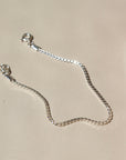 925 sterling silver bracelet laid on a tan paper in the sunlight