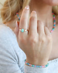 Model wearing the azura amazonite ring. This ring features a 6x8mm amazonite gemstone set in a 14k gold fill serrated bezel.