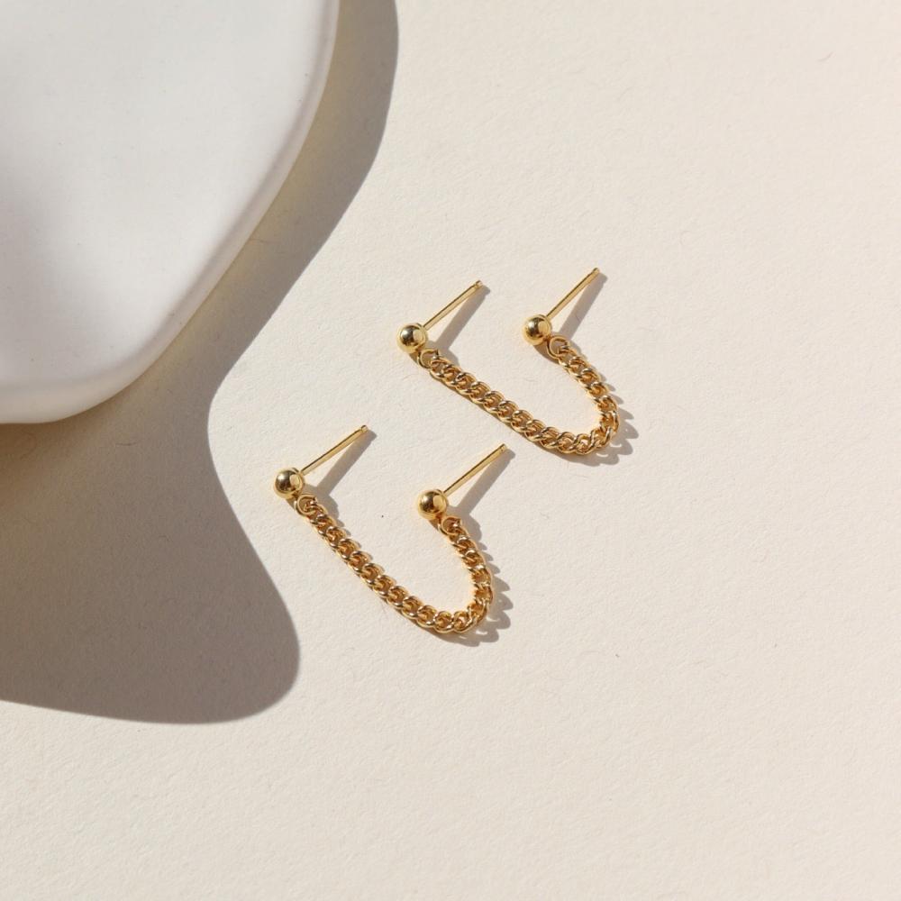 Two gold ball posts connected with a curb chain.