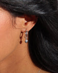 model wearing sterling silver heart charm on classic hoop earring