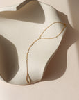 14k gold fill hand chain with pearls on a light dish