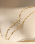 14k gold fill delicate cosette chain on wavy dish in the sunlight