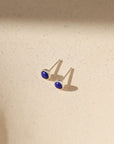 sterling silver ear posts with 4mm lapis lazuli stones on a light background