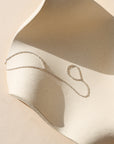 sterling silver hand chain laid on a wavy dish in the sunlight