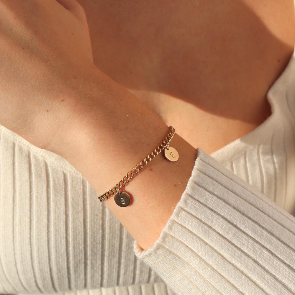 14k gold fill bold link chain Demi Alexandra Bracelet featuring two gold fill disks with a "B" and an "E", photographed on model wearing a white long sleeve t-shirt.