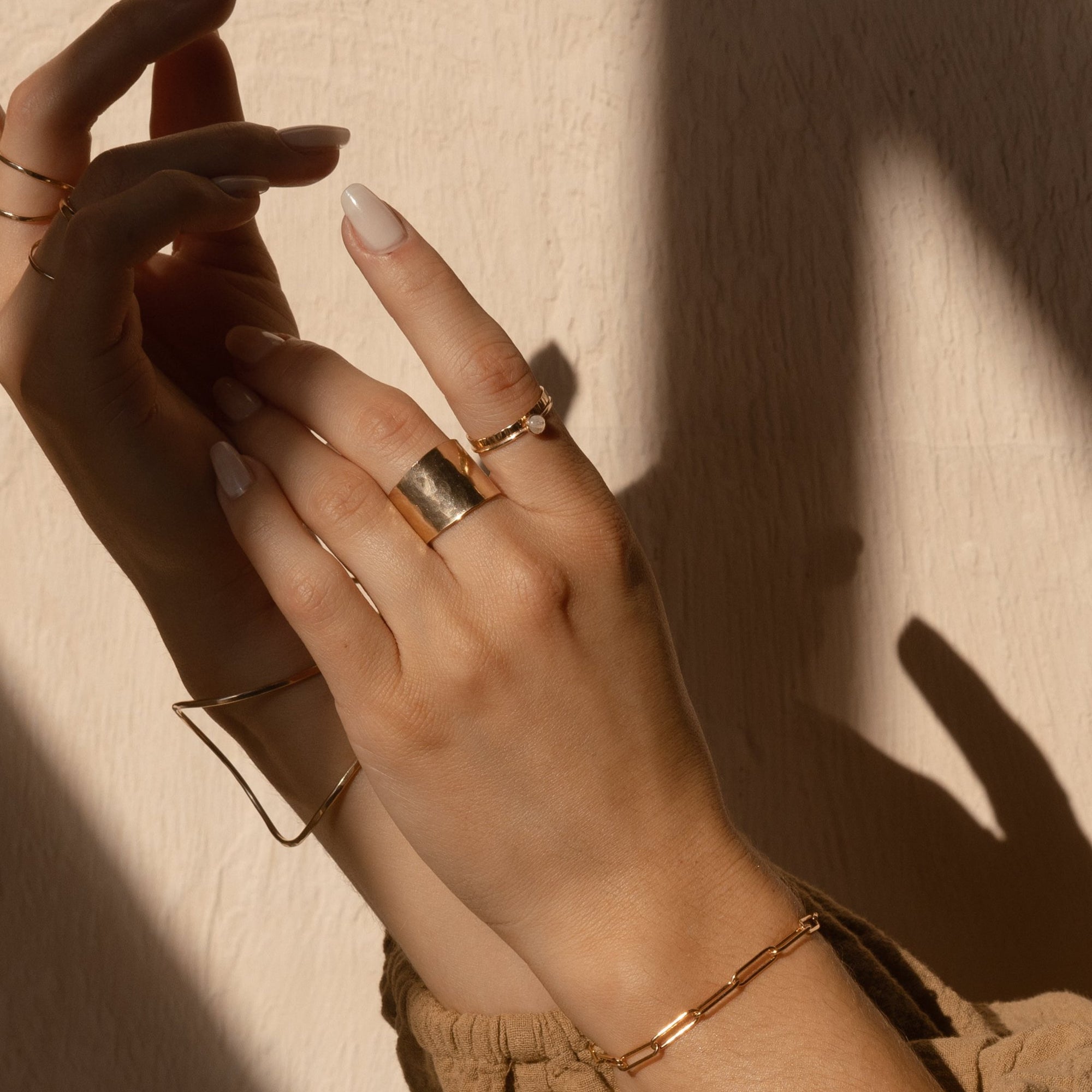 Model wearing 14k gold fill 4mm Moonstone Ring and other rings