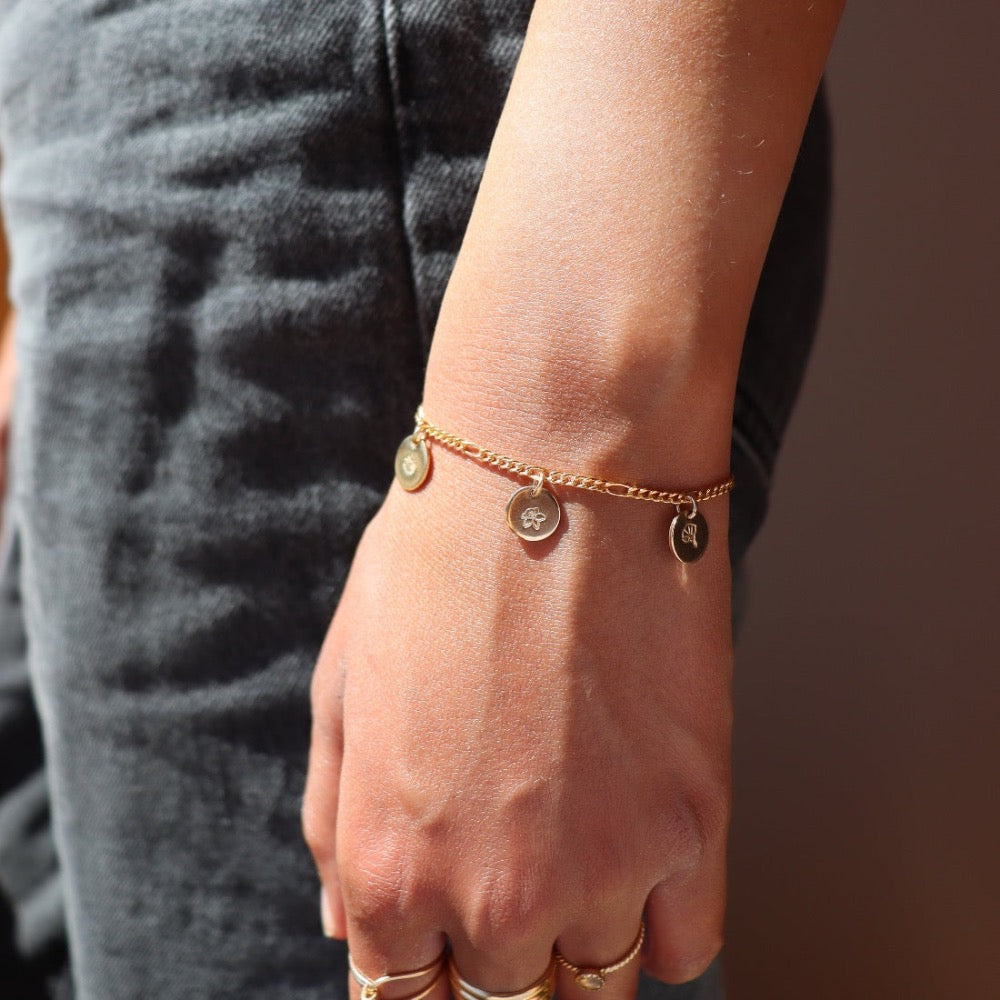Model wearing 14k gold fill Birth flower charm bracelet. This Bracelet feature the Demi Alexandra chain with as many birth flower charms as you want.