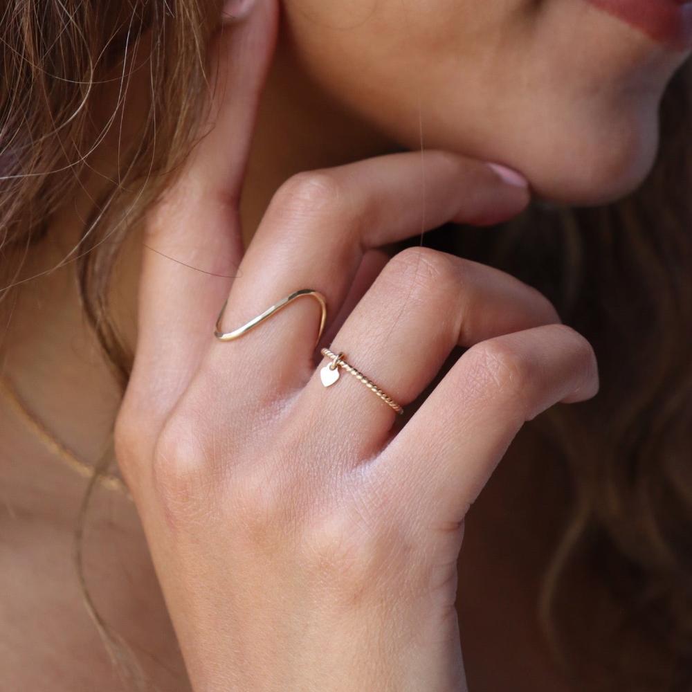 Model wearing 14k gold fill Heart Charmed Ring on ring finger
