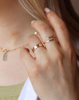Model wearing 14k gold fill initial stamped ring in the sunlight. This ring features a hammered band that you get to customize with name or initials of your choice.