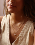 Model wearing Mother of Pearl Cross Necklace in 14k gold fill