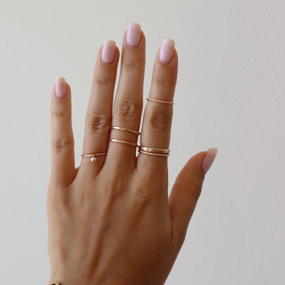 Model wearing spiral midi ring on pointer finger.