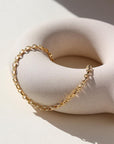 Roen Bracelet laid on a tan plate in the sunlight