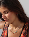 Model wearing Sedona Necklace with turquoise tube beads and red coral accents on a delicate gold filled chain.