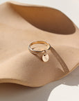 A smooth band stacked with a spiral 14k gold fill band, with a small "S" stamped disc attached to both rings.