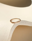 14k gold fill sequin ring displayed on wavy dish in sunlight