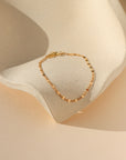 Gold sunburst chain bracelet with delicate textured links that catch the light.