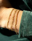 Gold sunburst chain bracelet with delicate textured links that catch the light.