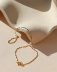 Gold sunburst hand chain featuring delicate textured links and a raw Herkimer diamond accent.