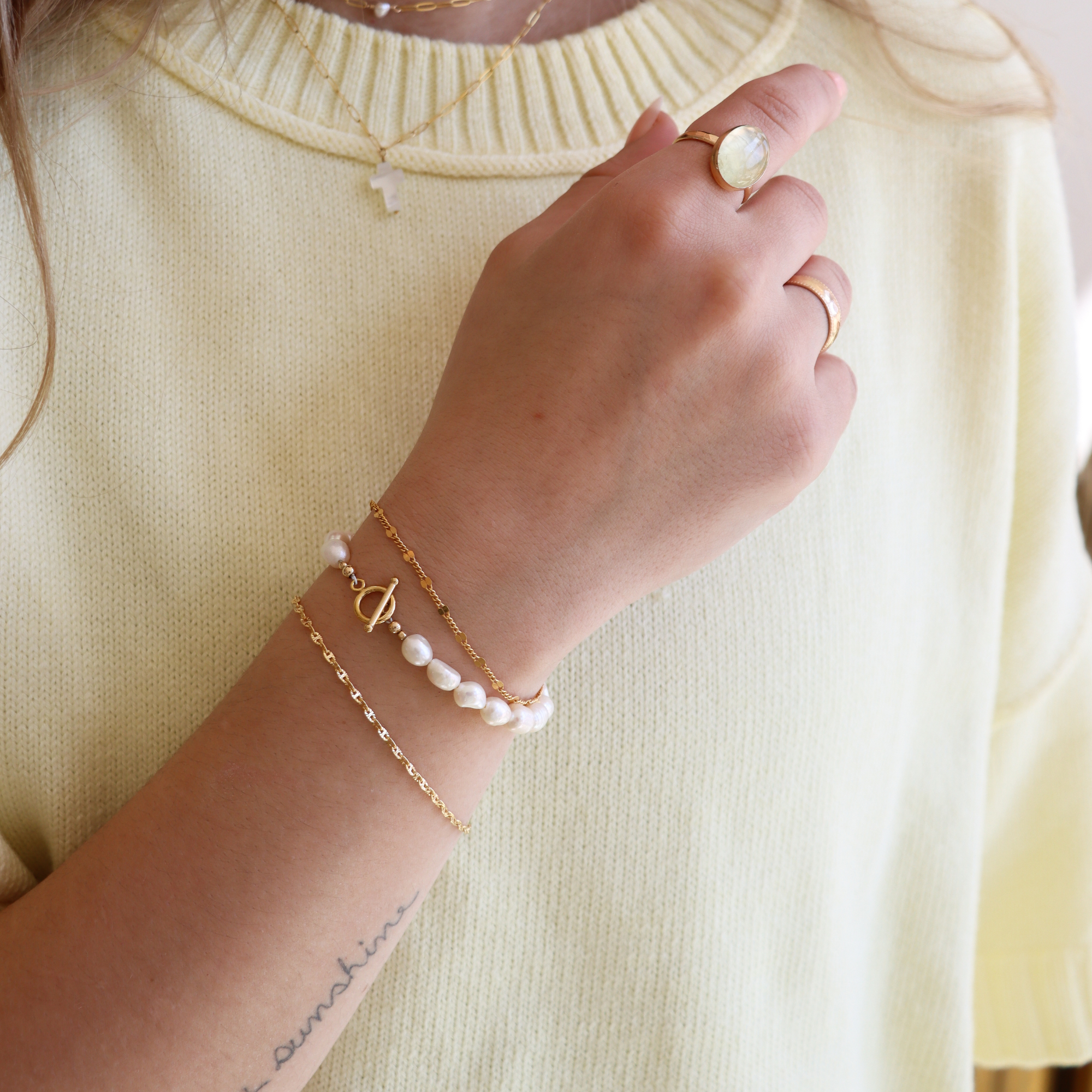 14k Gold Fill Freya Chain Bracelet, a delicate minimalist gold chain bracelet layered with a freshwater pearl bracelet and styled with everyday gold jewelry.