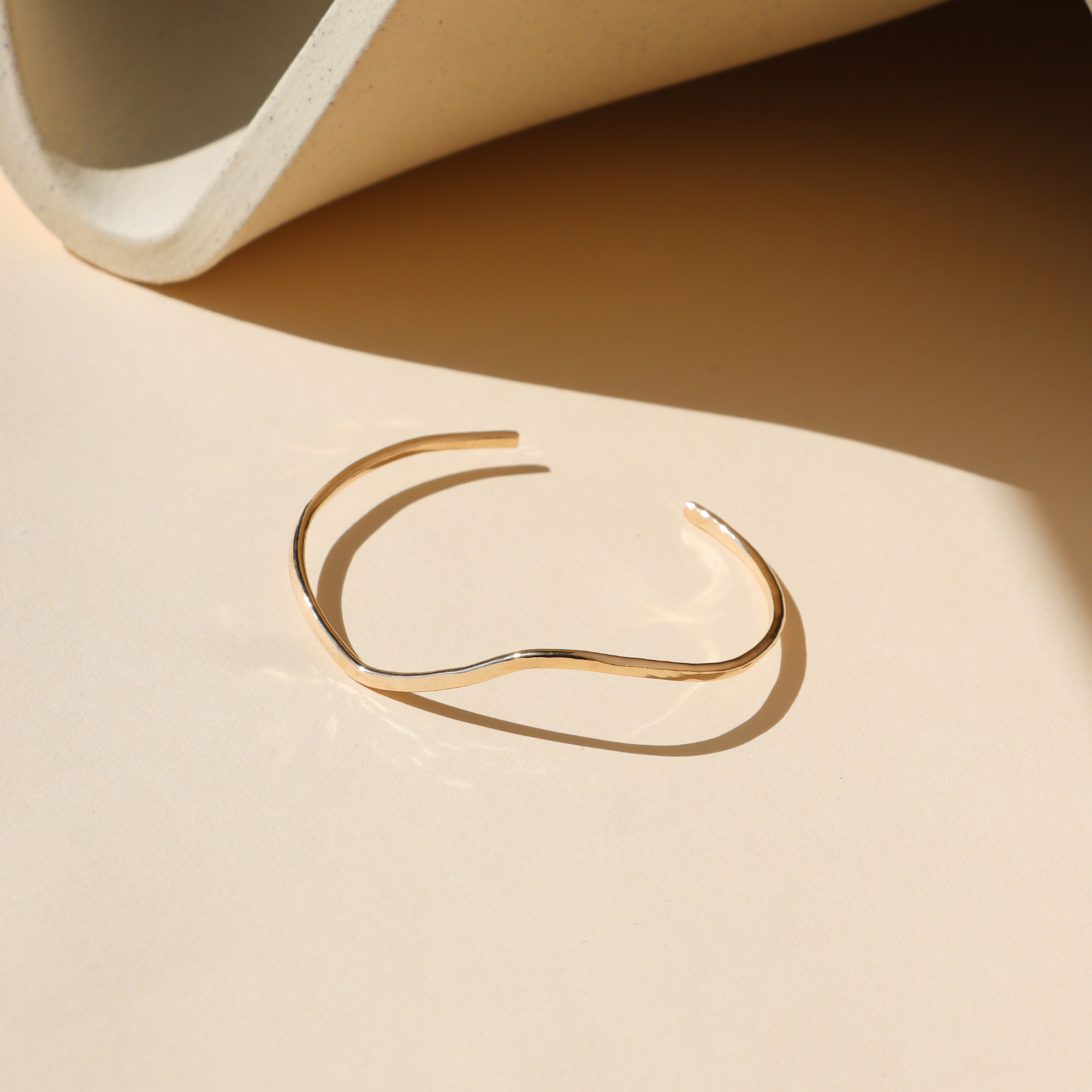 14k Gold Fill Swell Cuff Bracelet featuring a sculptural organic wave design, minimalist open cuff bracelet displayed in warm natural light.