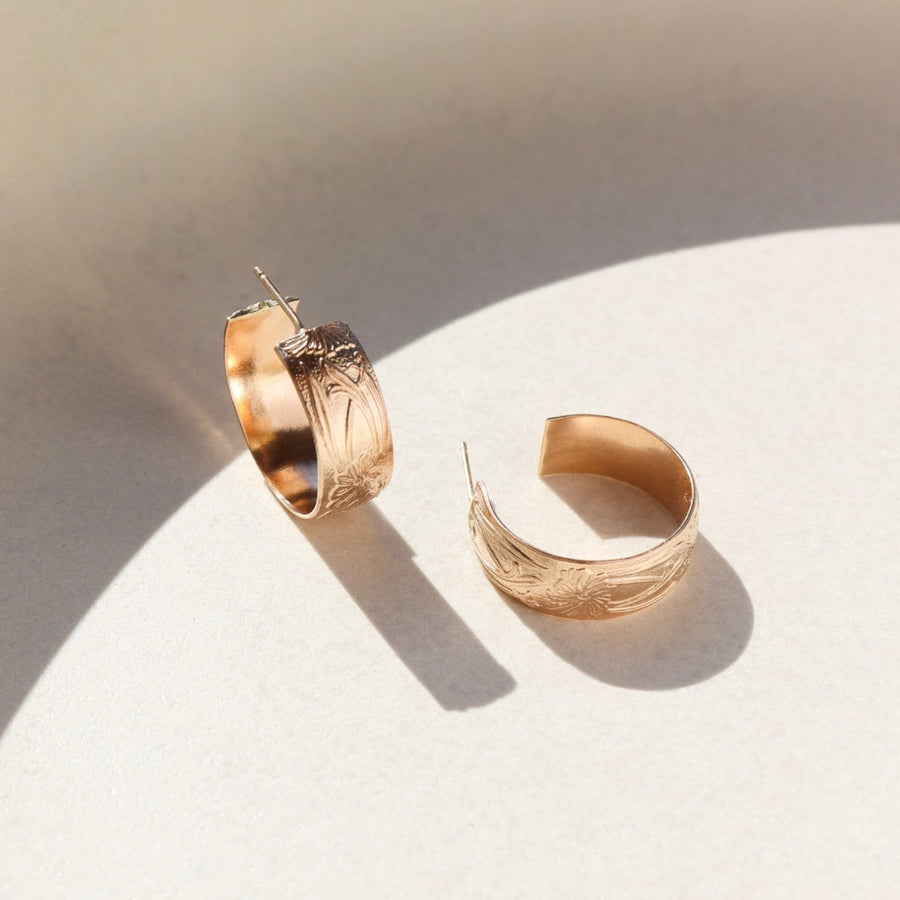 14k gold fill Florence hoops laid on a white plate in the sunlight