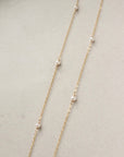 dainty pearls on a 14k gold filled chain photographed on a ceramic dish