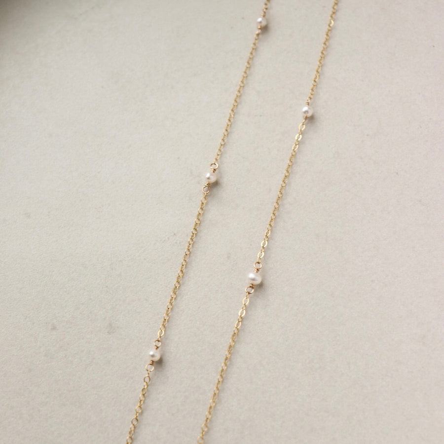 dainty pearls on a 14k gold filled chain photographed on a ceramic dish