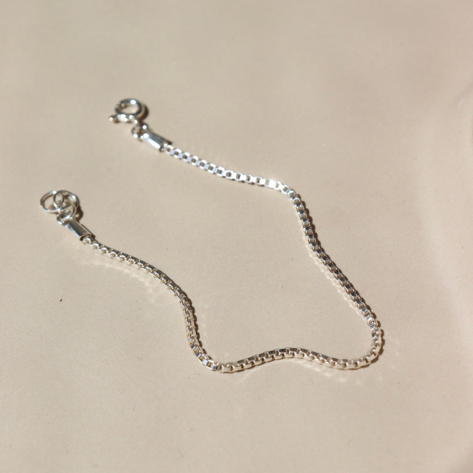 925 sterling silver bracelet laid on a tan paper in the sunlight