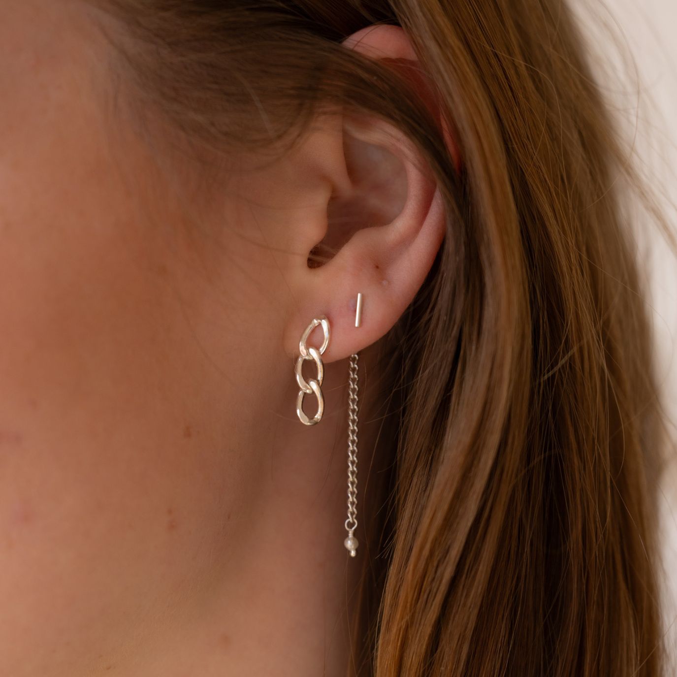 model wearing 14k gold fill chain earrings with pearl accent and bar stud earring