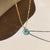 Amazonite donut shaped gemstone pendant attached to a 14k gold Fill chain in the sunlight