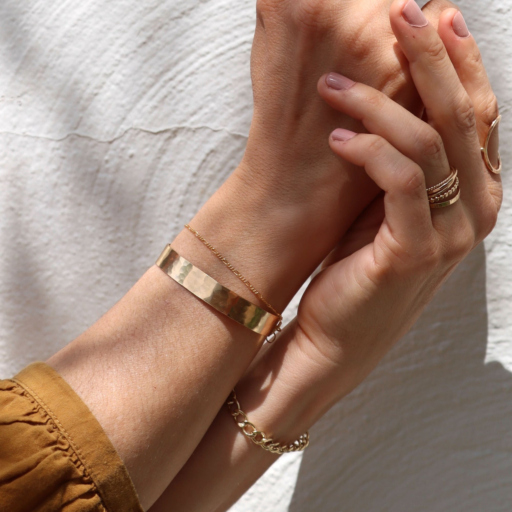 model wearing 14k gold fill delicate figaro bracelet with a hammered gold fill cuff bracelet