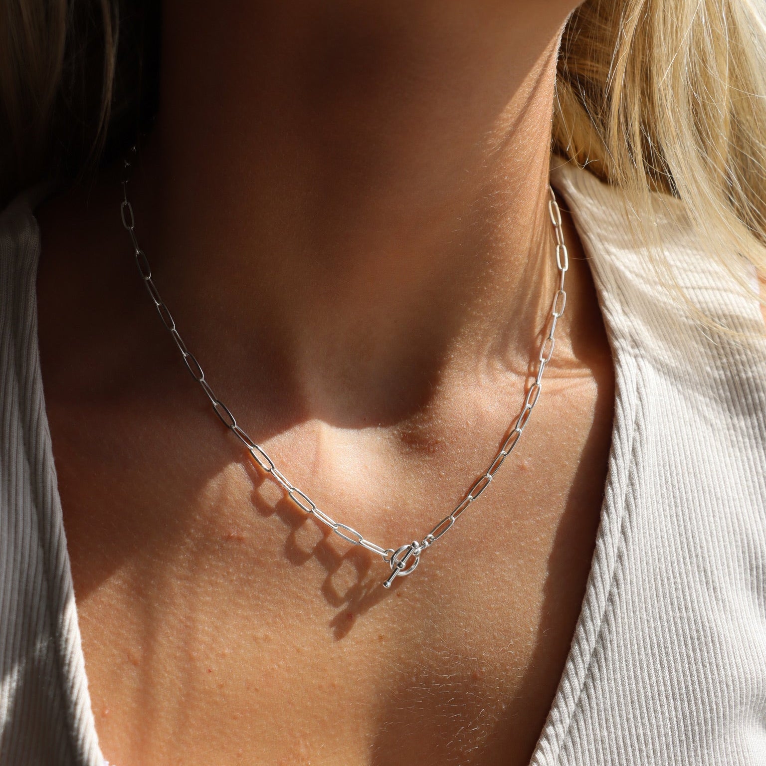 model wearing sterling silver paperclip chain necklace with toggle clasp