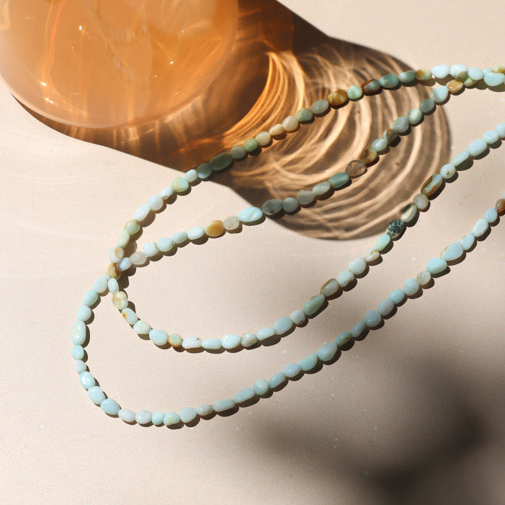 oval blue opal beaded necklace on a light surface