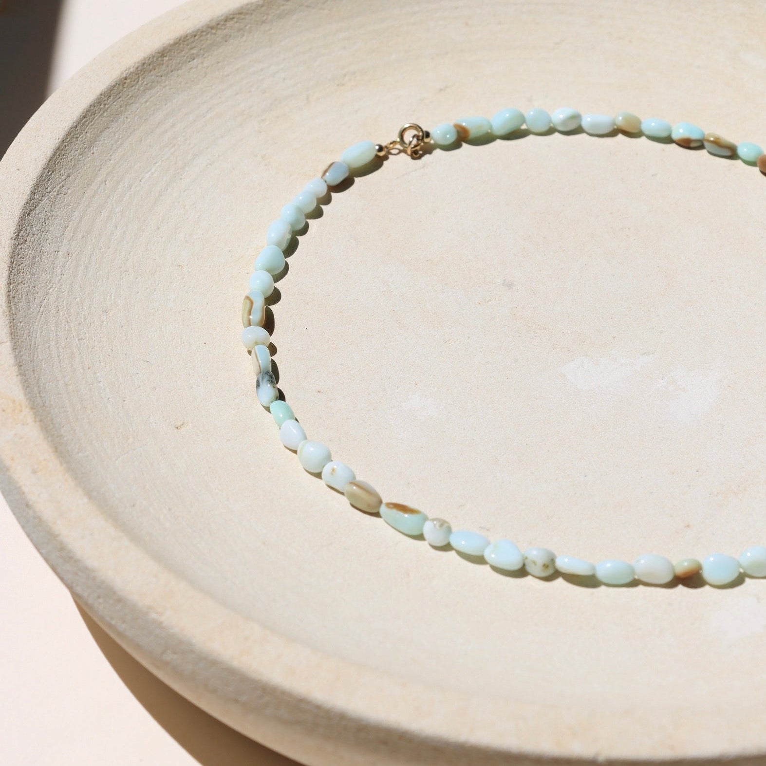 oval blue opal beaded necklace on a light surface