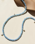 A 14k gold fill fully beaded necklace featuring blue opal gemstones and 6 freshwater pearls. The necklace is displayed on a cream back drop. 