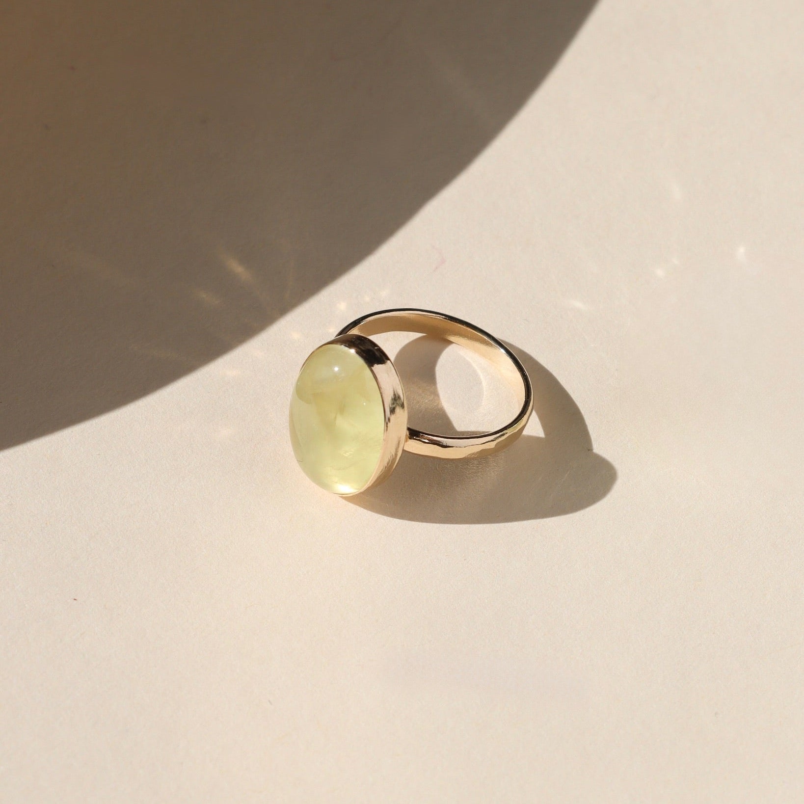 14k gold fill bezel ring with prehnite stone on a light background
