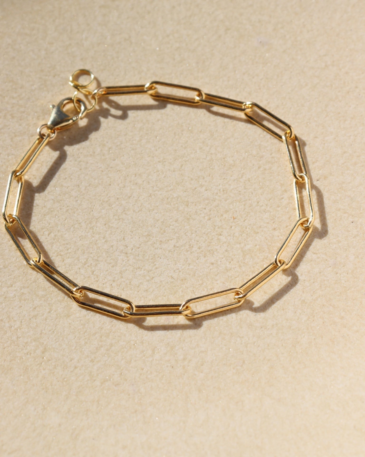 large paperclip chain bracelet in gold fill on a light dish 