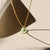 Chrysoprase donut shaped gemstone pendant attached to a 14k gold Fill chain in the sunlight