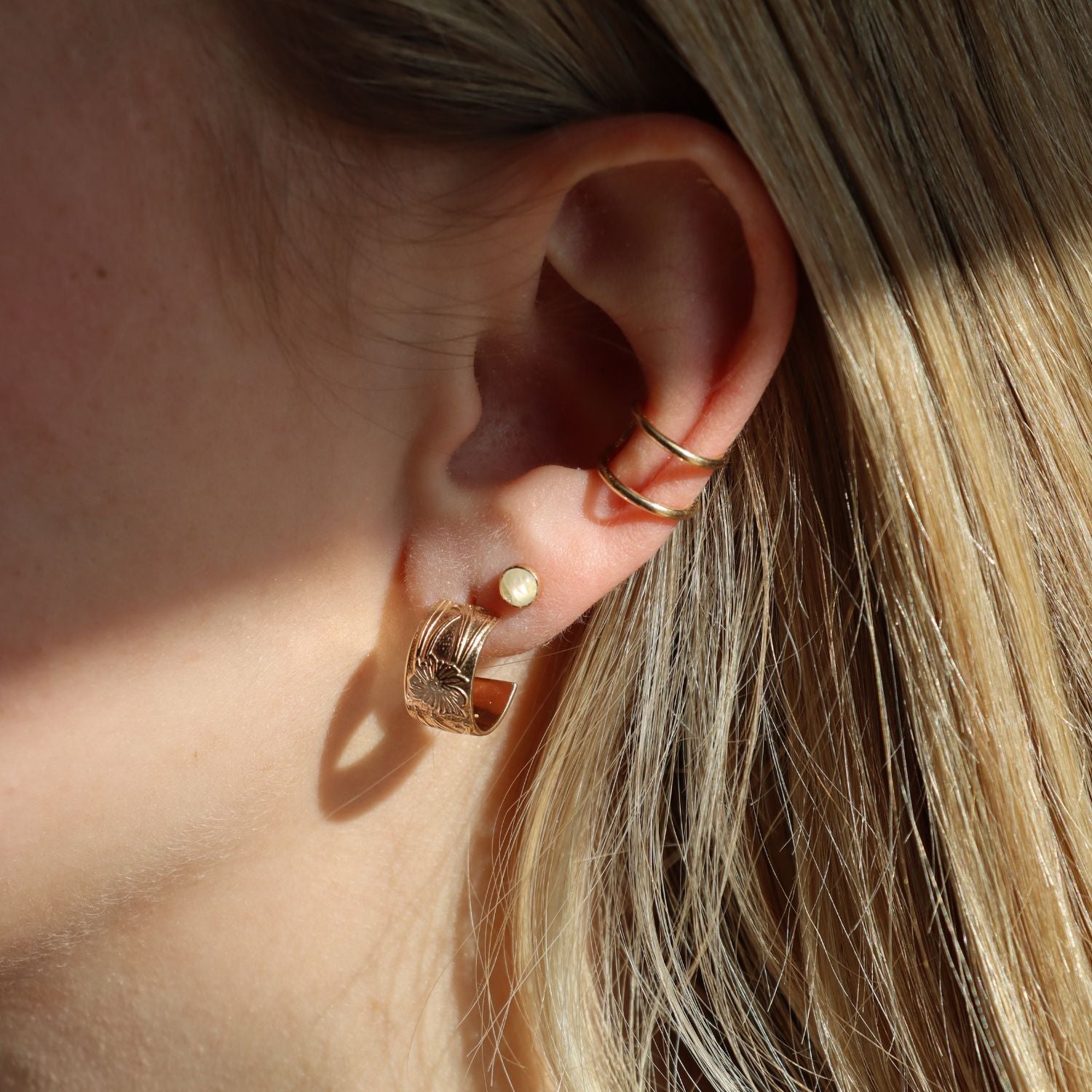 model wearing 14k gold fill textured hoops with ear cuff and gemstone studs