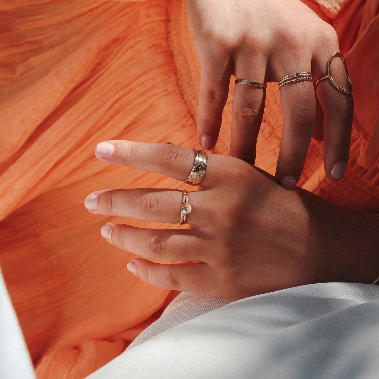 model wearing 14k gold fill delicate band ring with curved disc with other 14k gold fill rings 