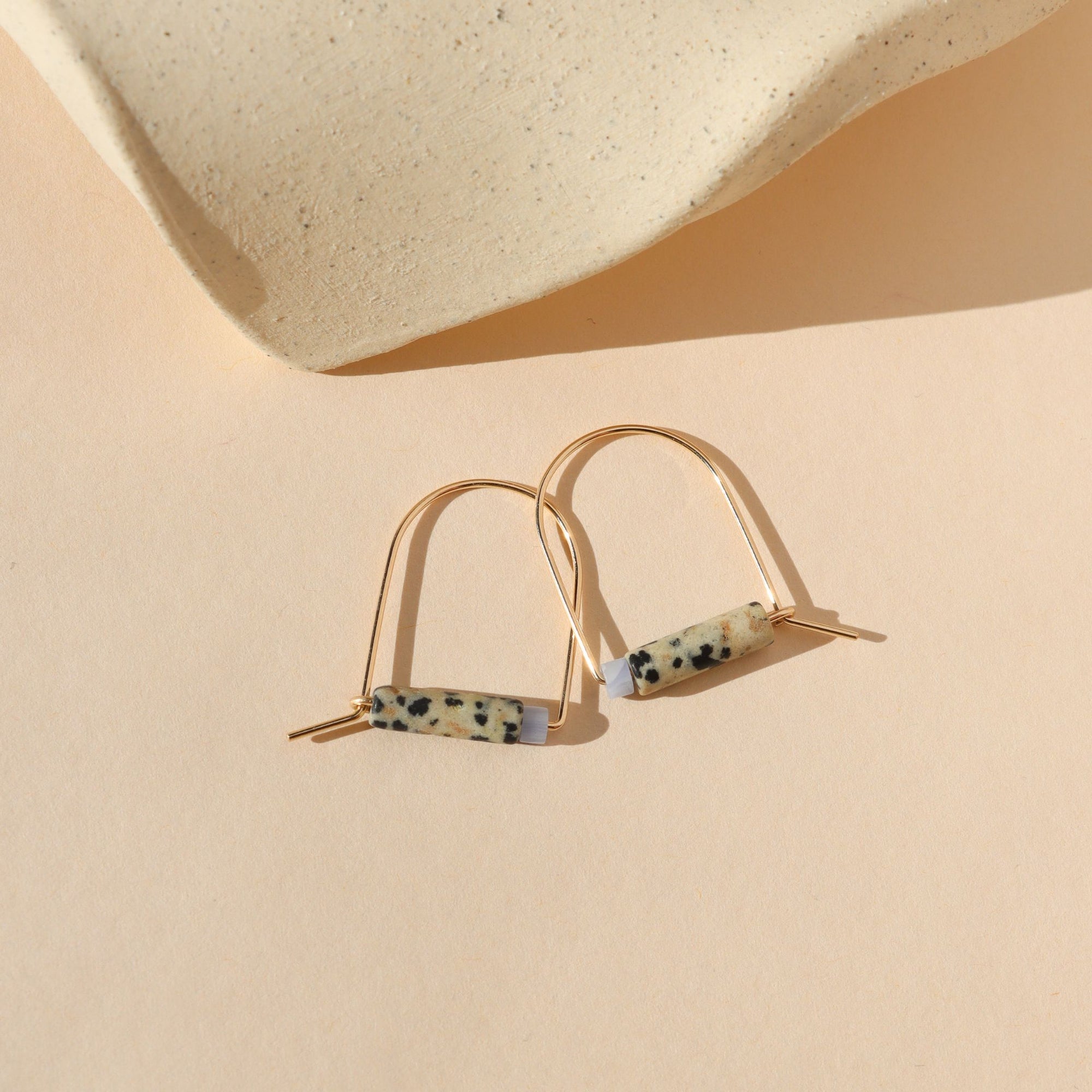 14k gold fill arch shaped earrings with dalmatian jasper & blue lace agate beads on a light background