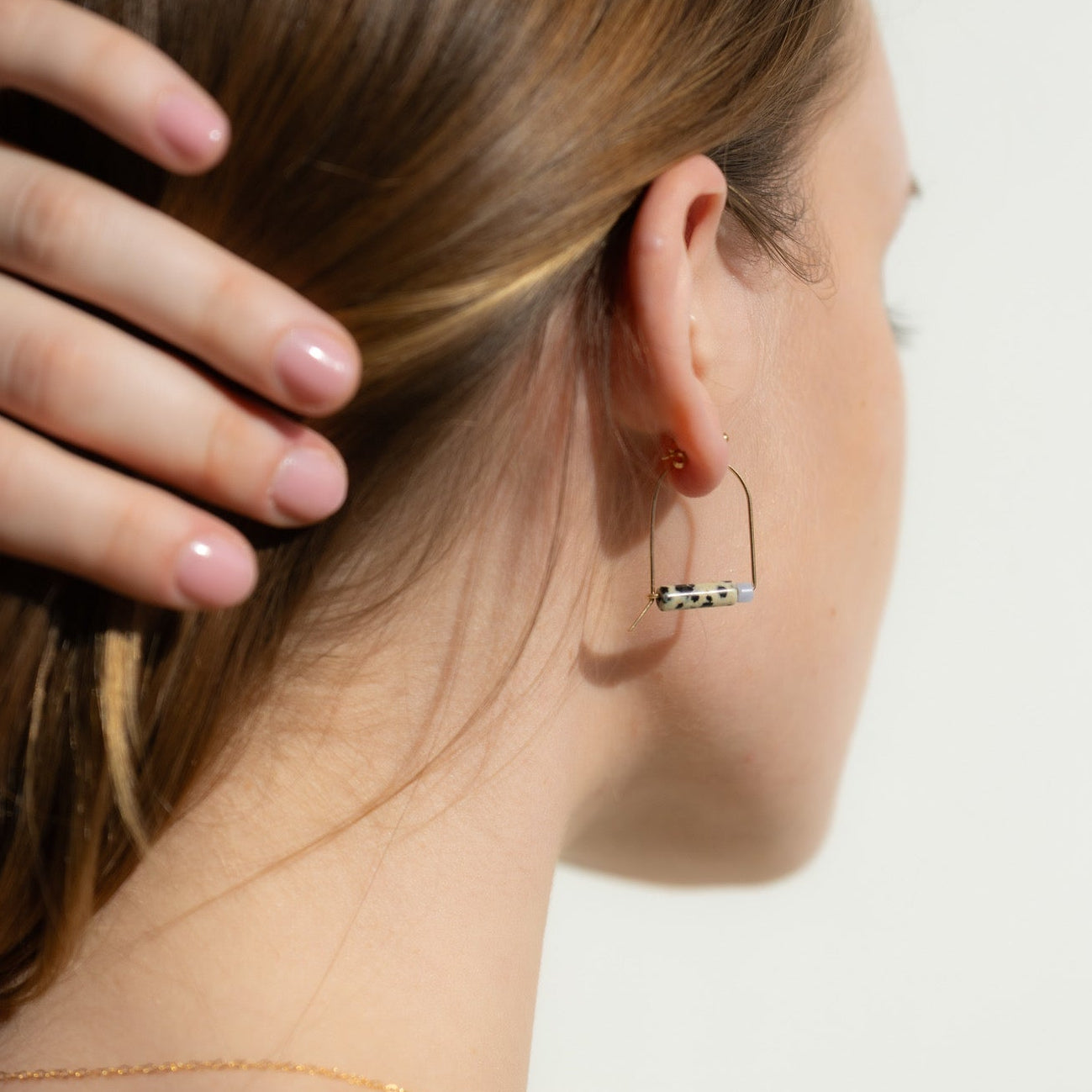 model wearing 14k gold fill arch shaped earrings with dalmatian jasper and agate beads