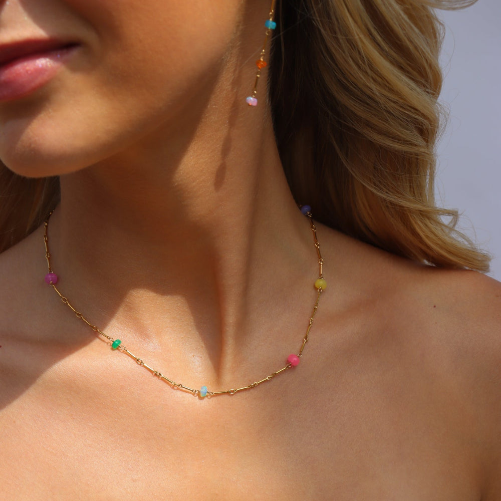 Model wearing a 14k Gold Fill necklace featuring six vibrant opals and a textured chain with bar, dot, and dash links.
