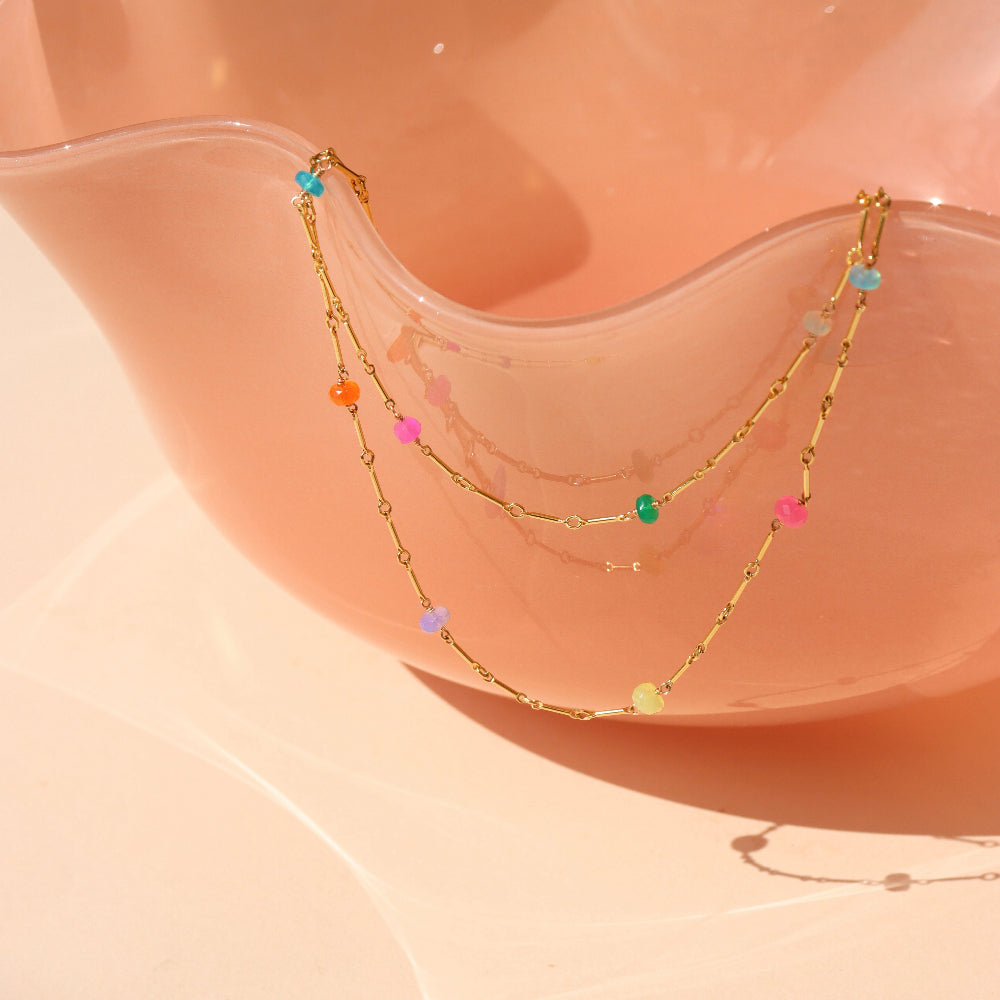 Disco Opal Necklace draping on a pink dish.