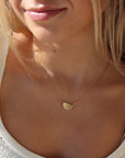 model wearing 14k gold fill half moon necklace. This necklace features a half circle hammered in the middle each side connected by the cosset chain.