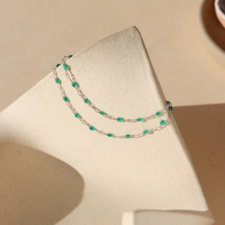 sterling silver chain with emerald enamel links on a light dish